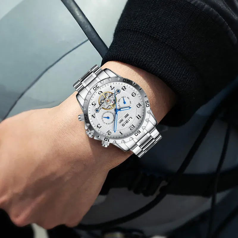 Men's silver automatic perpetual calendar mechanical watch with stainless steel strap on a wrist.