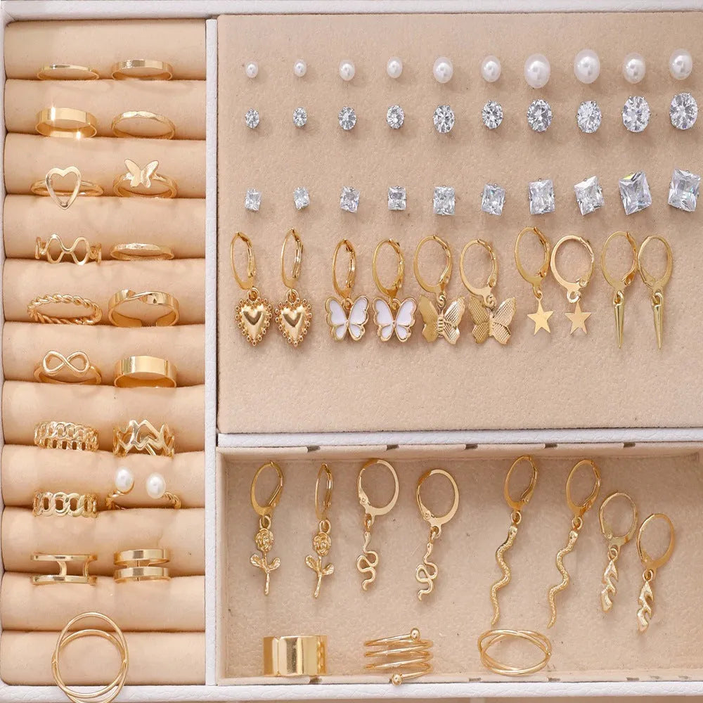 108 gold and yellow geometric alloy earrings with pearl details laid out flat.