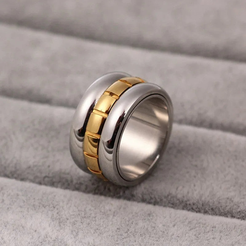 Gold titanium steel ultra-wide knuckle ring with a rotatable tail, shown on a finger.