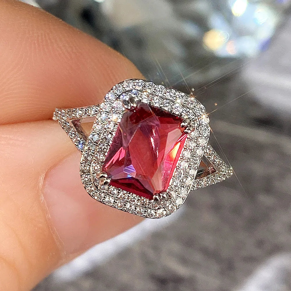 Women's geometric copper ring with a square red rhinestone on a hand.