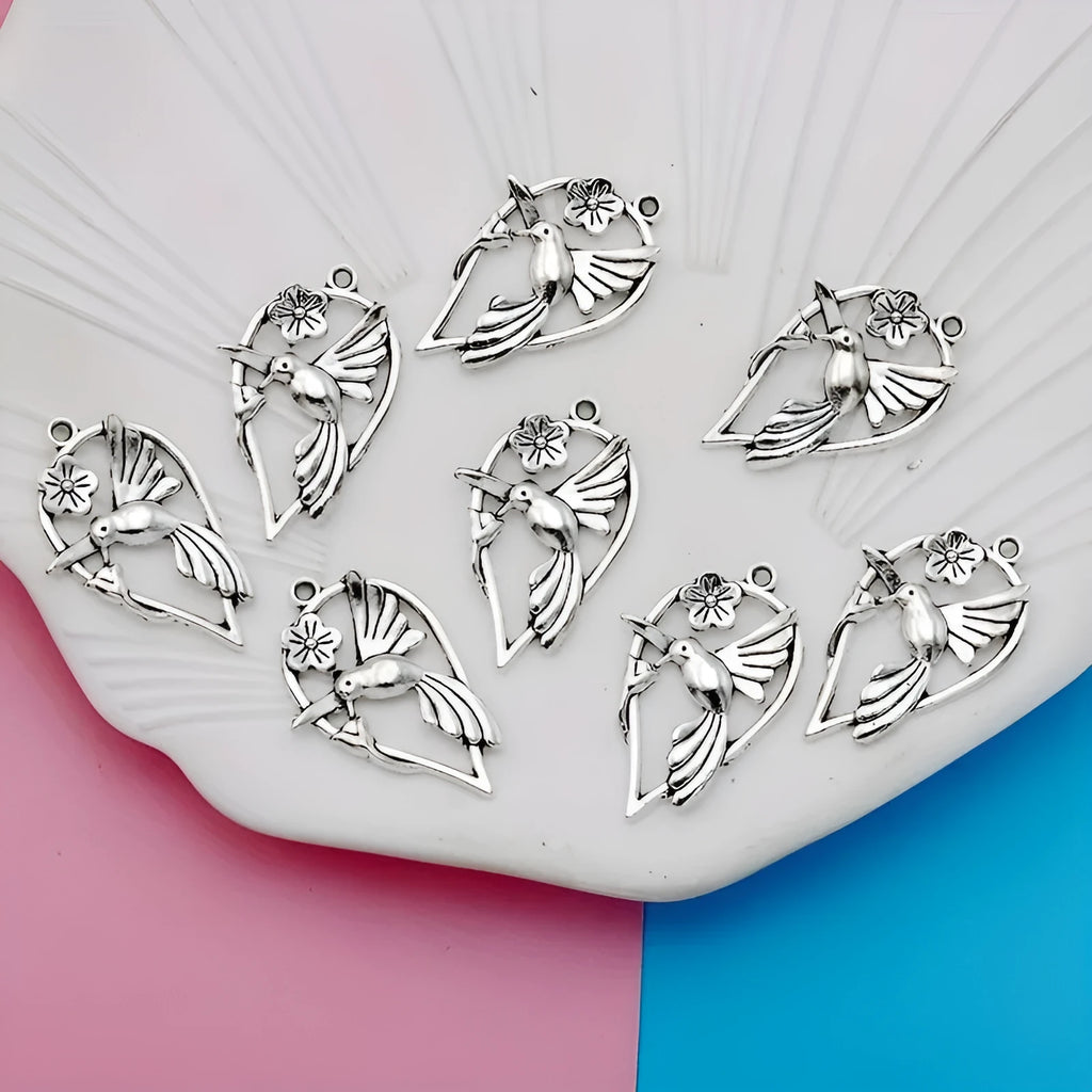 Close-up of a silver-coloured alloy pendant shaped like a magpie bird with detailed feathers, on a white background.