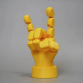 Yellow movable joint hand prop figurine with articulated fingers on a neutral background.