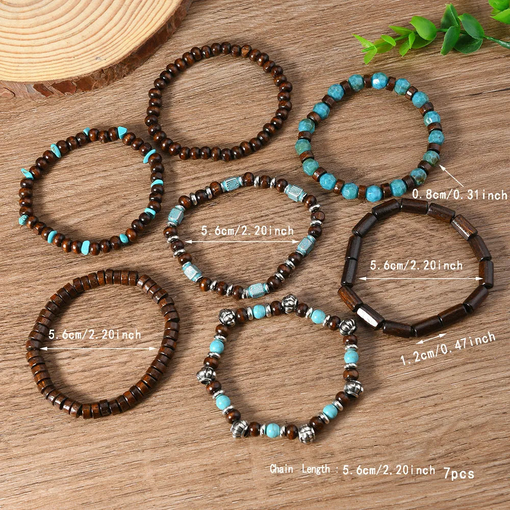 Set of seven multicolour retro bracelets with wooden beads and alloy charms laid flat.