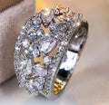Women's round hollow copper fashion ring on a hand, showing gold and platinum finish options with blue and white accents.