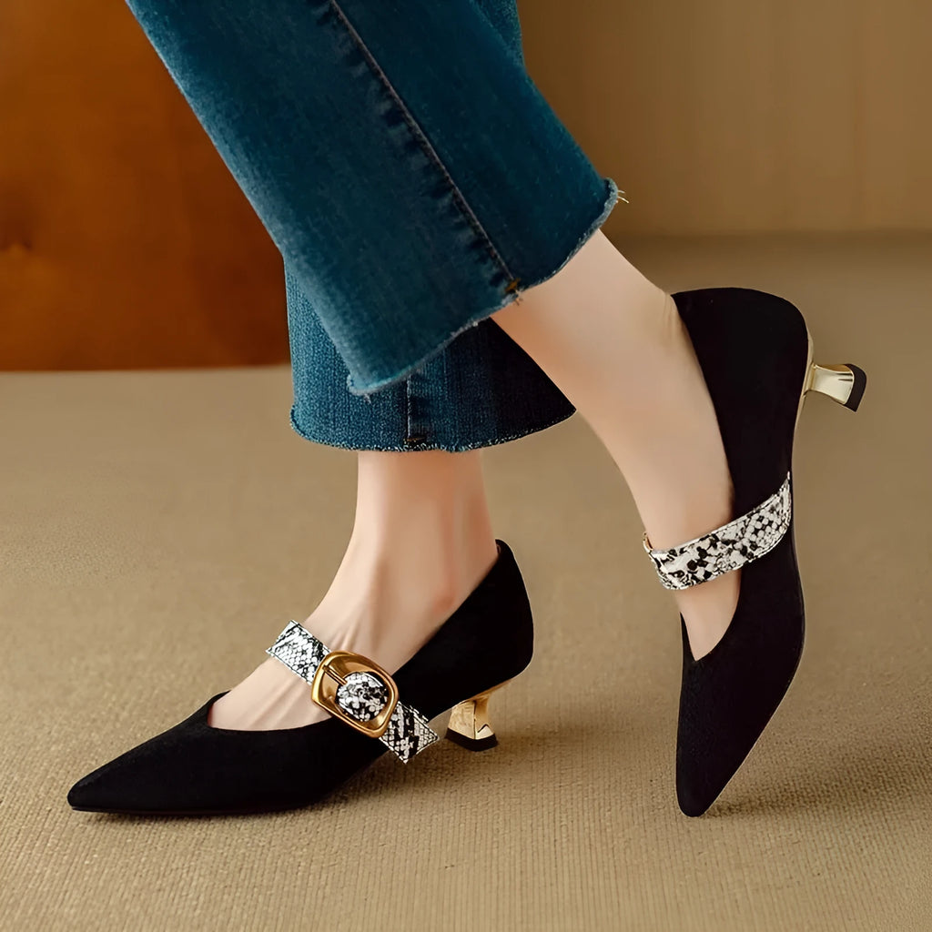 Women's black pointed-toe stiletto heels with an ankle buckle on a rubber sole