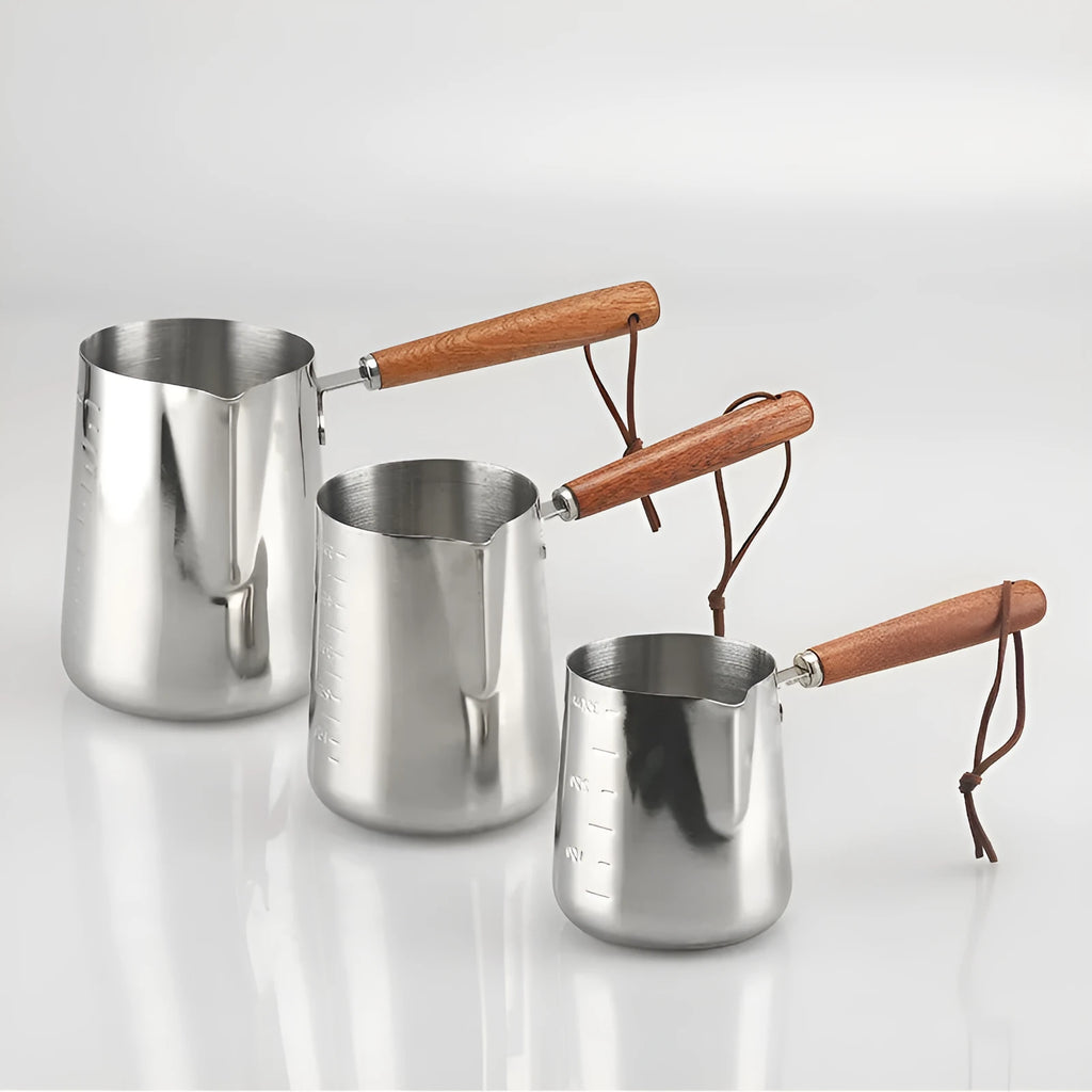 Stainless steel coffee cup with wooden handle and visible millilitre scale markings.