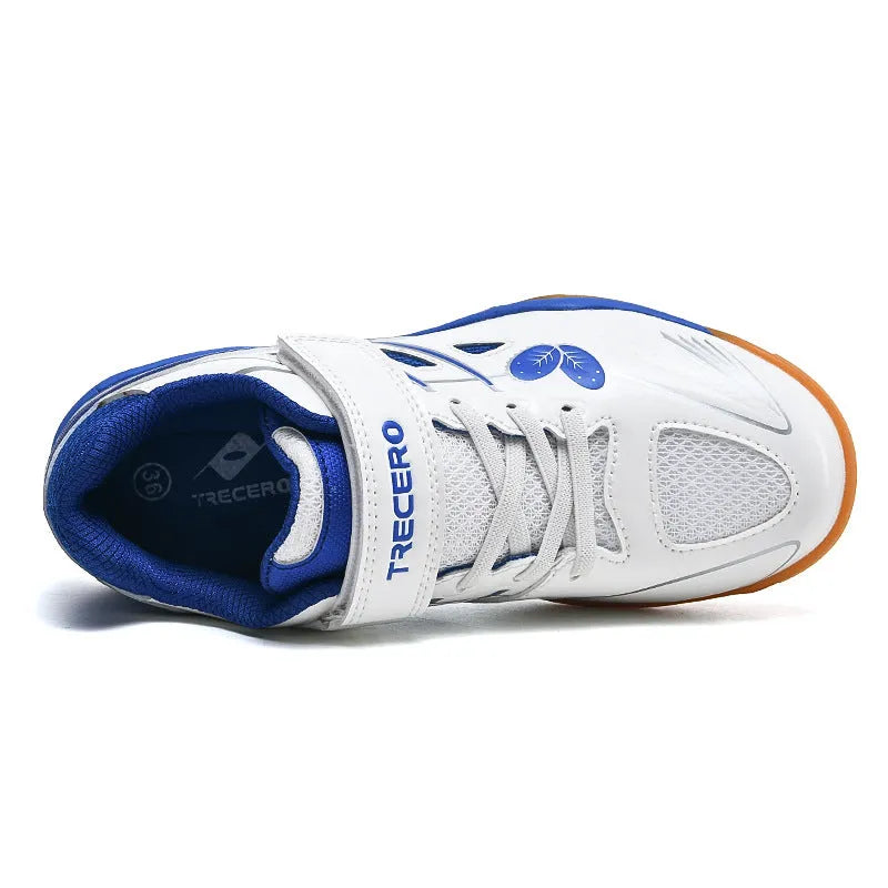 White and blue children's low-top badminton shoes with a ribbed sole on a court surface.
