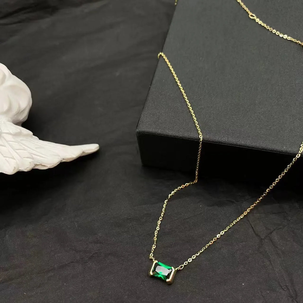 Gold geometric quadrilateral pendant necklace with inlaid cubic zirconia stones on a matching chain.