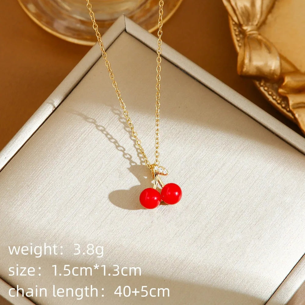 Delicate red fruit charm necklace on a titanium steel O-ring chain, showing gold and steel colour options.