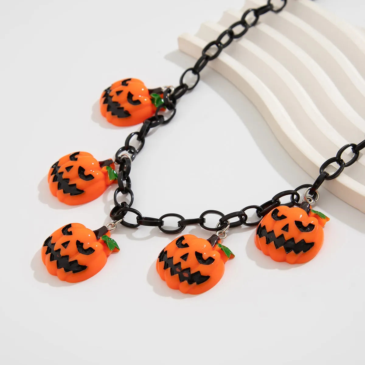 Halloween necklace showing a cartoon ghost and pumpkin acrylic pendant on a chain, colour 06705.