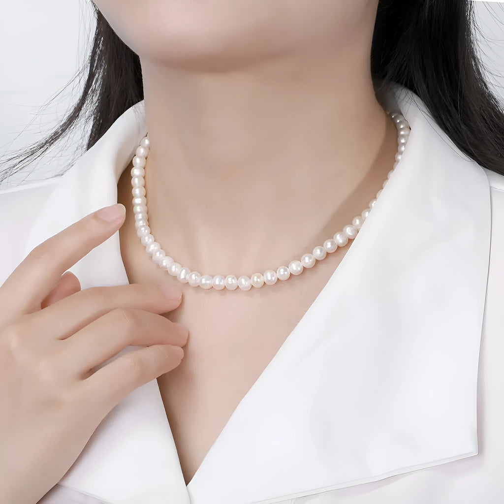 Close-up of a silver adjustable necklace with a single natural freshwater pearl pendant.