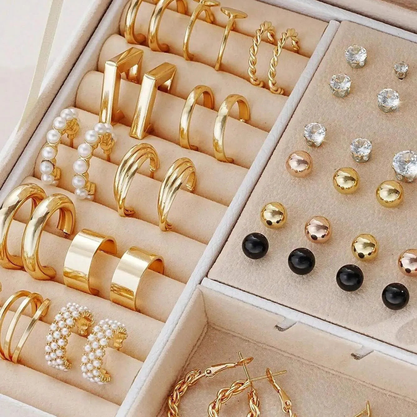 108 gold and yellow geometric alloy earrings with pearl details laid out flat.
