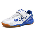 White and blue children's low-top badminton shoes with a ribbed sole on a court surface.