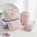 Set of four soft pink flannelette cube makeup bags with zips, arranged from largest to smallest.