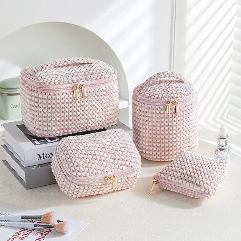 Set of four soft pink flannelette cube makeup bags with zips, arranged from largest to smallest.