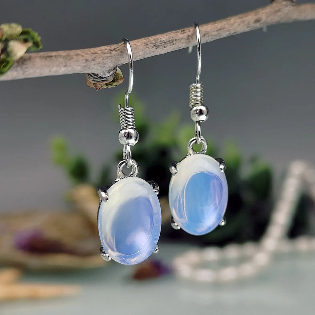 A pair of retro-style drop earrings with a moonlight opal centre on an electroplated alloy setting.