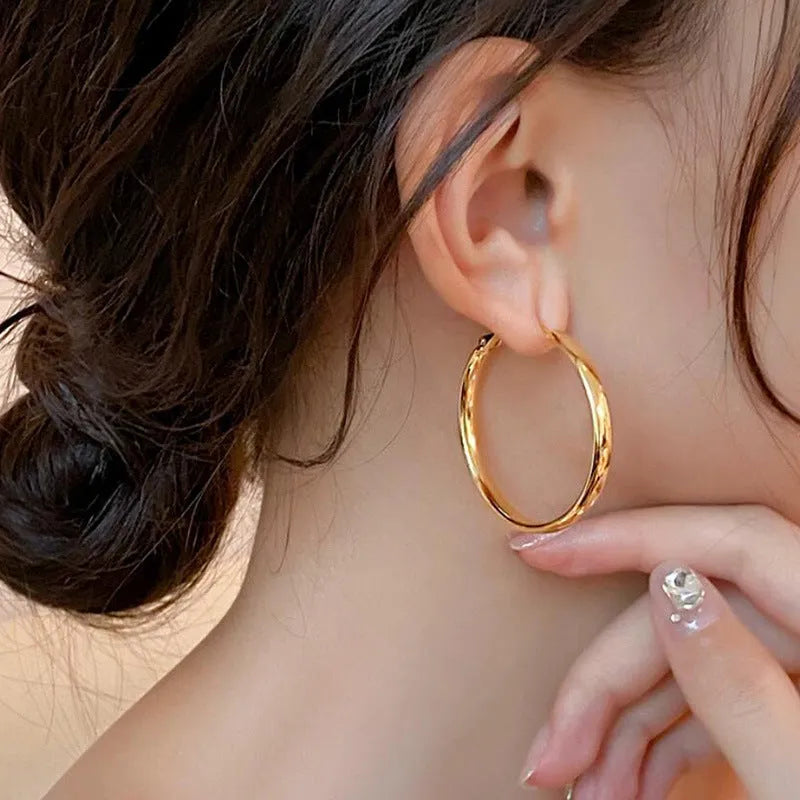 A pair of large gold-coloured metal circle earrings measuring 40mm in diameter