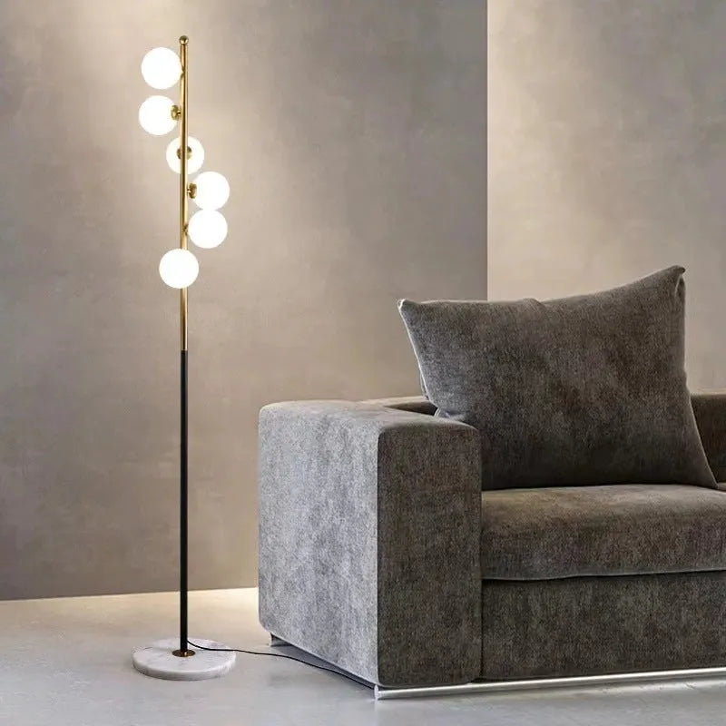 Tall minimalist Nordic floor lamp with wrought iron stem, glass fittings, and a circular white marble base.