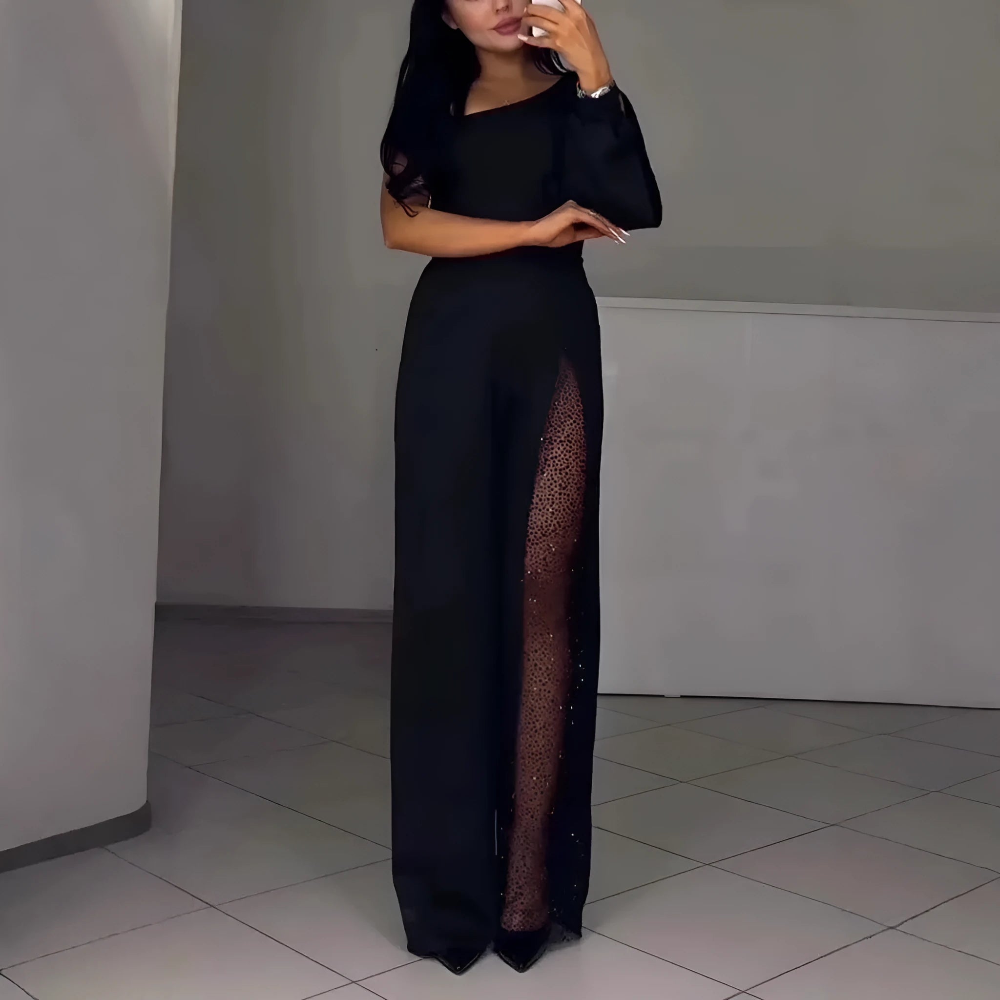 Black women's long sleeve jumpsuit with an oblique shoulder neckline and a high slit on the leg.