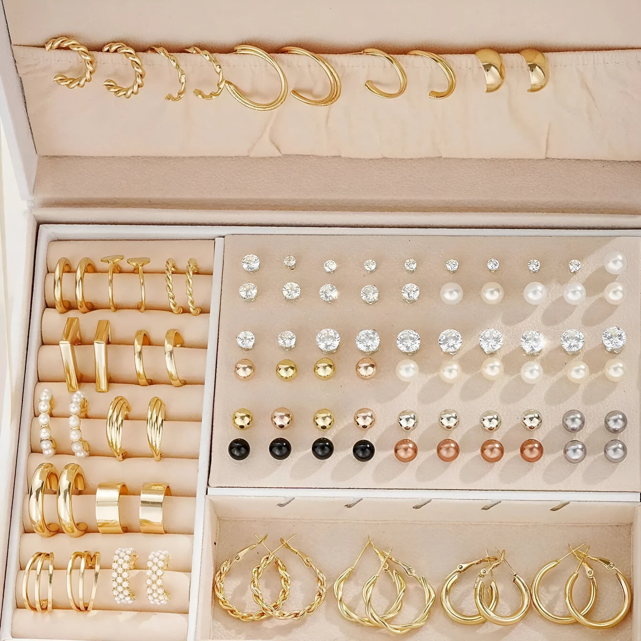 108 gold and yellow geometric alloy earrings with pearl details laid out flat.