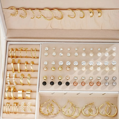 108 gold and yellow geometric alloy earrings with pearl details laid out flat.