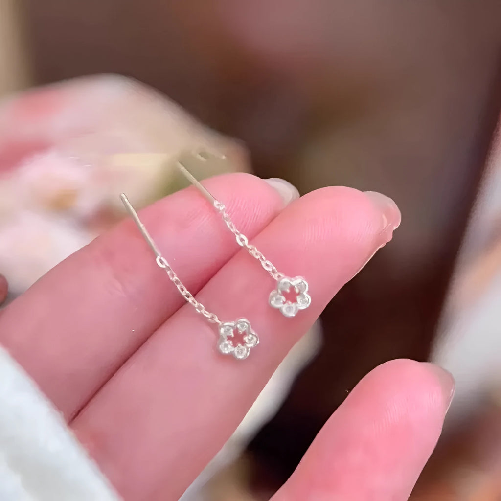 Silver hollow flower hanging earrings with petal detailing and needle fastening