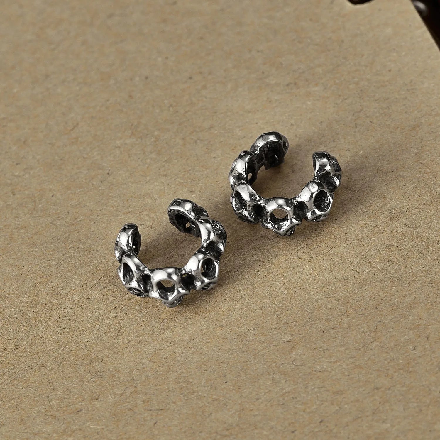 Stainless steel skull earrings with hollow geometric design and clip-on style