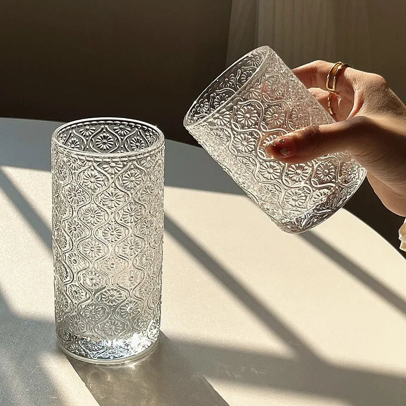 Begonia patterned glass drinking cup in short and tall sizes on a table.