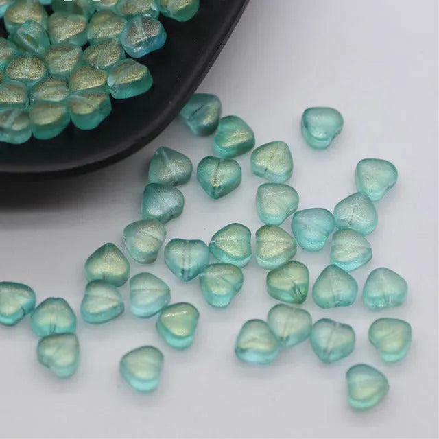 Twenty transparent Czech glass love heart spacer beads in assorted colours including aurora purple and peach gold.