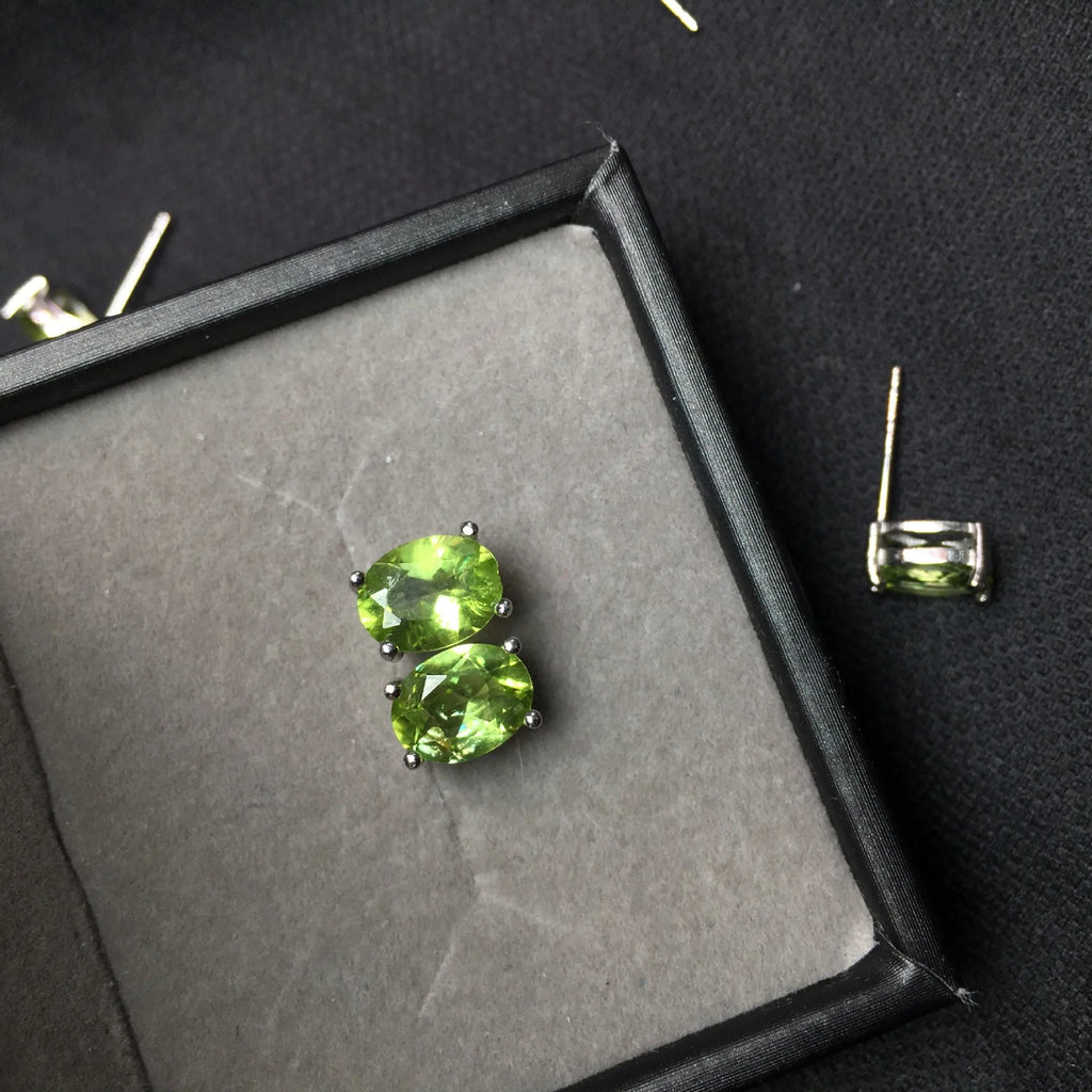 Close-up of grass green natural olivine stud earrings in S925 sterling silver setting.