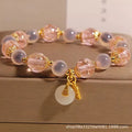 Close-up of a women's pink agate heart bracelet with a luminous glaze and a silver peace buckle clasp.