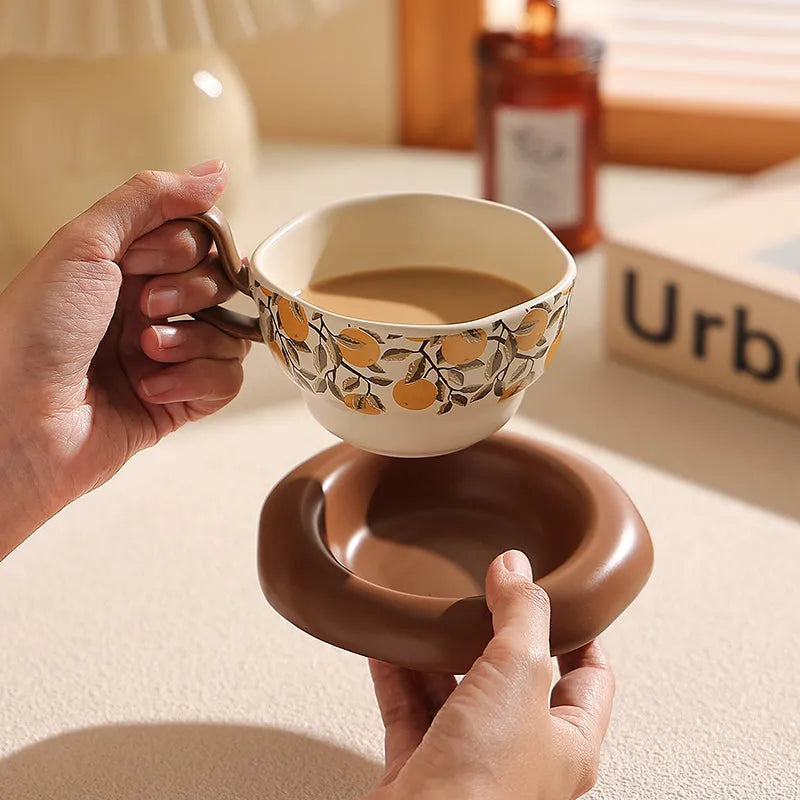 Antique style ceramic coffee cup and saucer with 210ml capacity, shown in black pomegranate and orange Citrofortunella design options.