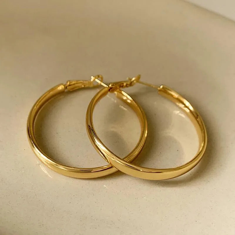 A pair of large gold-coloured metal circle earrings measuring 40mm in diameter