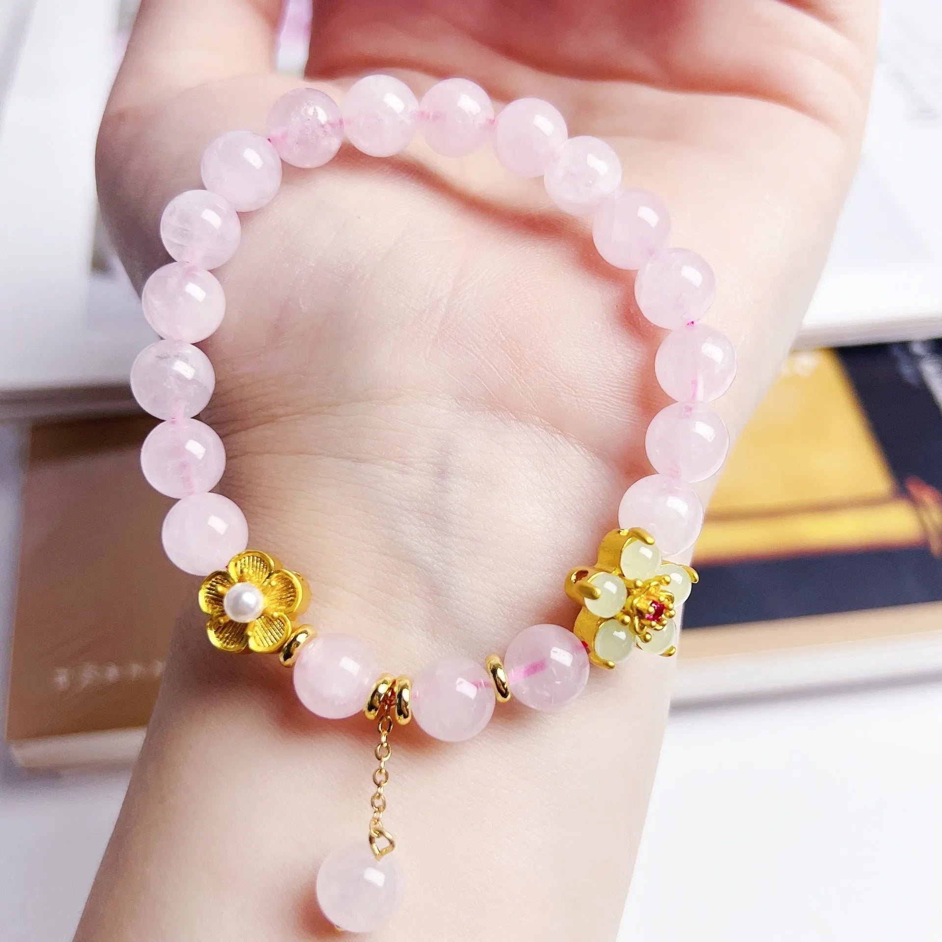 Close-up of a handmade pink crystal peach blossom bracelet on a wrist, showing adjustable closure.