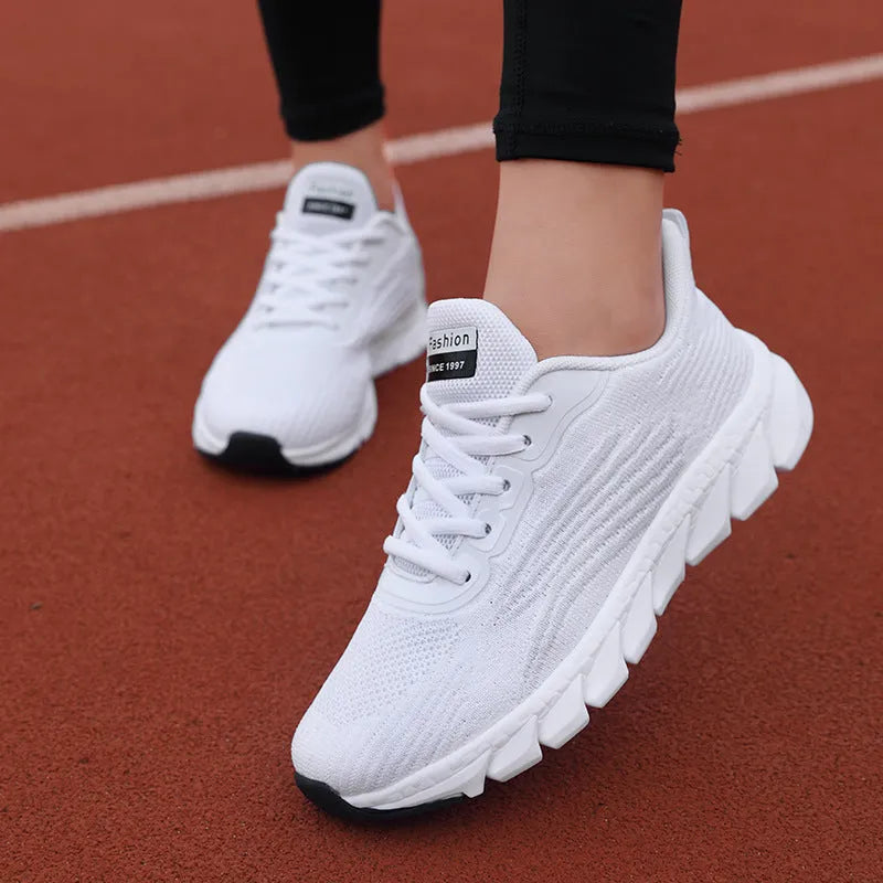 Women's black and white low-top running sneakers with cross strap design and MD soles