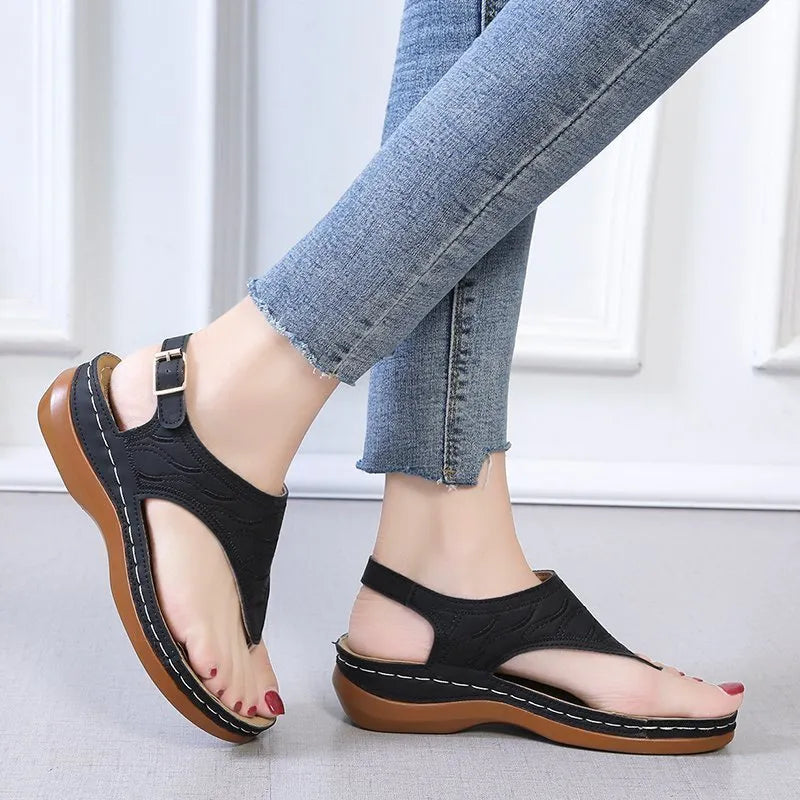 Women's wedge heel flip flop sandals with an adjustable back strap in solid black.