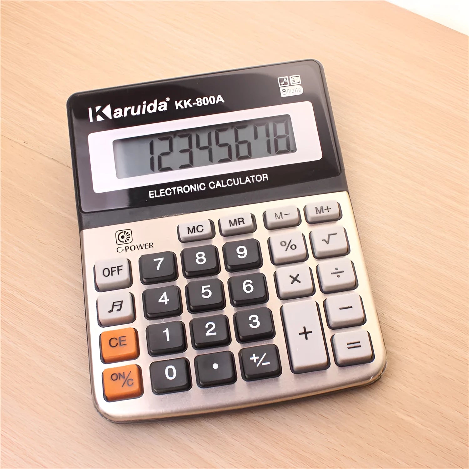 Silver aluminium desktop calculator with compact 14.5x11cm size on desk