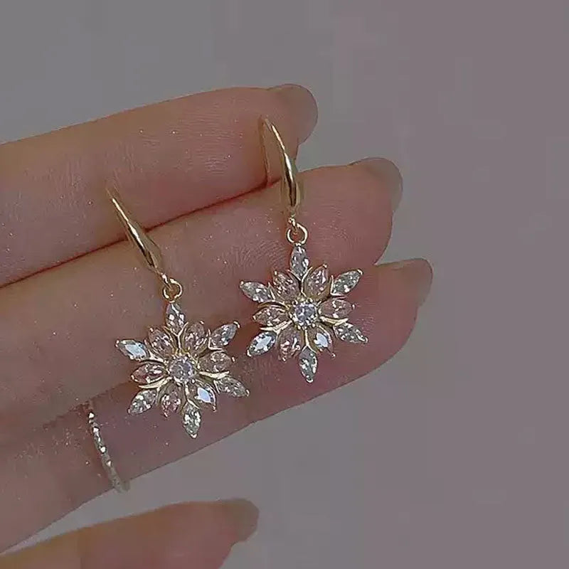 Gold alloy snowflake earrings with central zircon stone for women