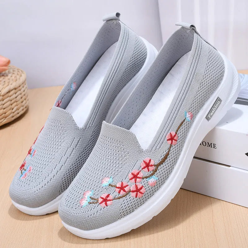 Women's black woven ballet pumps with floral embroidery and a flat anti-slip sole.