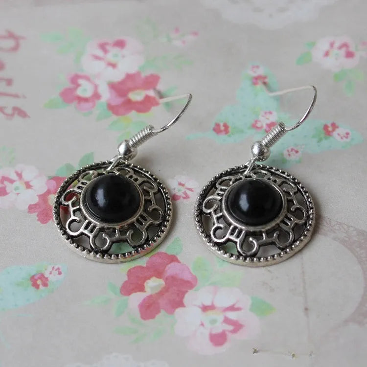 Handmade geometric silver earrings with turquoise flower disk and ethnic patterns in red, blue, or black.