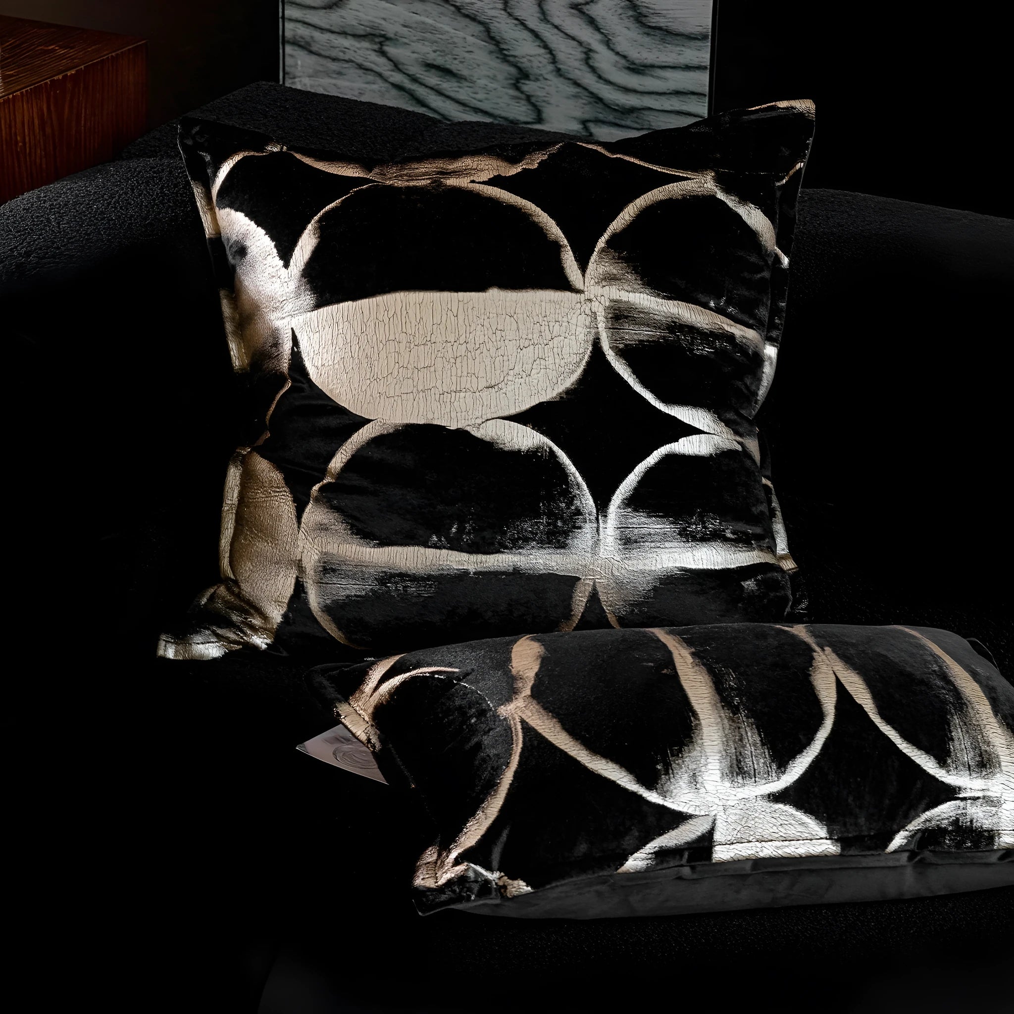 Black and gold abstract pattern flannel pillow cushion on a sofa, shown with removable cover.