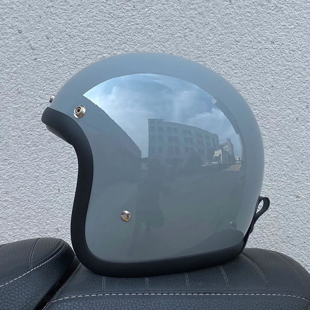 Retro-style open-face motorcycle helmet in cement grey with a textured finish and quick-release chin strap.