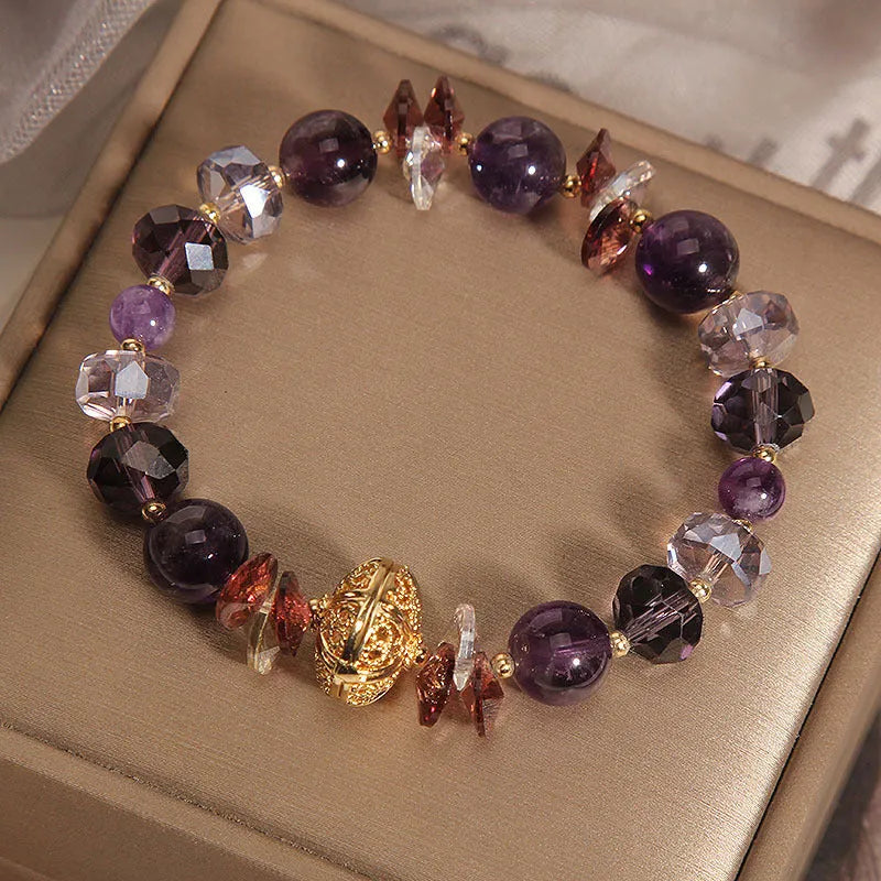 Purple crystal bracelet with pumpkin beads and rhinestone decoration on a wrist.