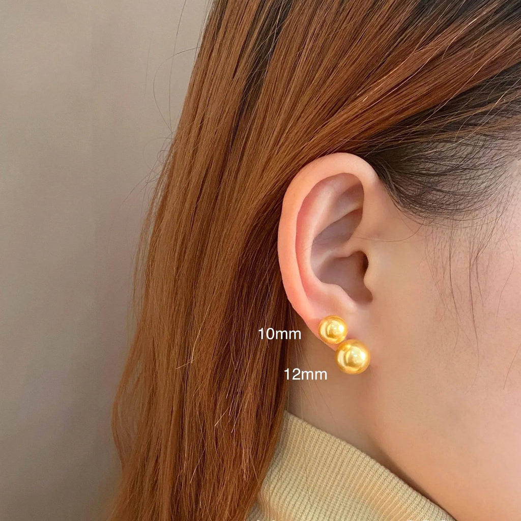 Close-up of a women's large pearl stud earring with an eight-point geometric silver star setting.
