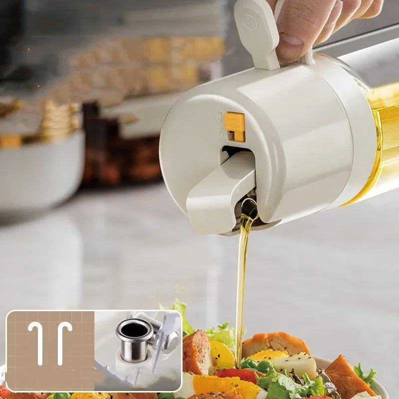 Warm grey glass oil sprayer bottle with a dual-mode cap switch, shown on a kitchen counter.