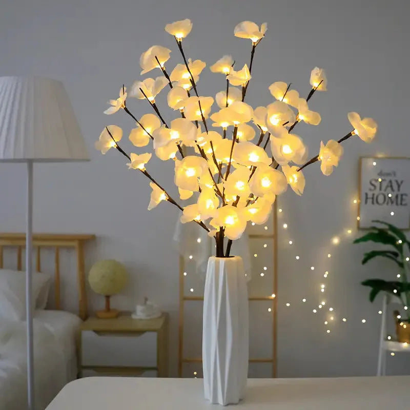 Pink Phalaenopsis-shaped LED decorative light with a bendable 65cm fabric branch on a wooden table.