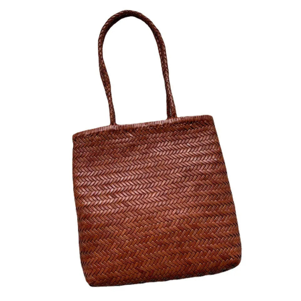 Brown handmade cowhide leather woven tote bag with a three-dimensional front pocket.