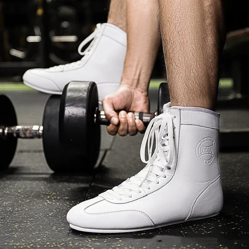 Professional boxing shoes with leather and mesh construction in black gold colour with non-slip soles
