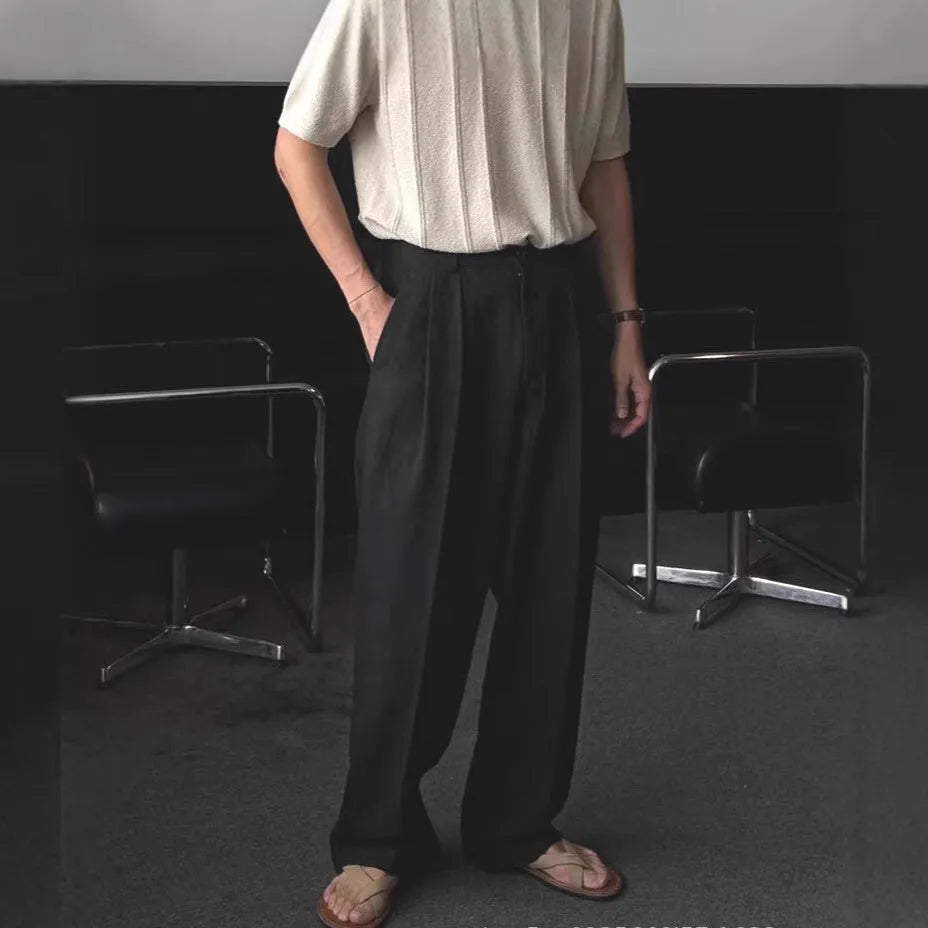 Men's apricot coloured loose-fit cotton linen suit trousers with a pencil leg on a neutral background.