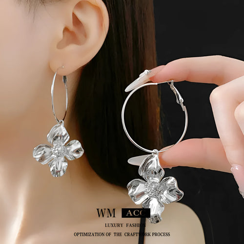 A pair of vintage-style floral drop earrings with geometric silver needle details, shown in a gold electroplated finish.